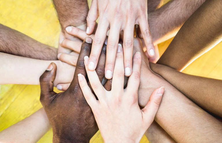 Top view of multiracial stacking hands - International friendshi